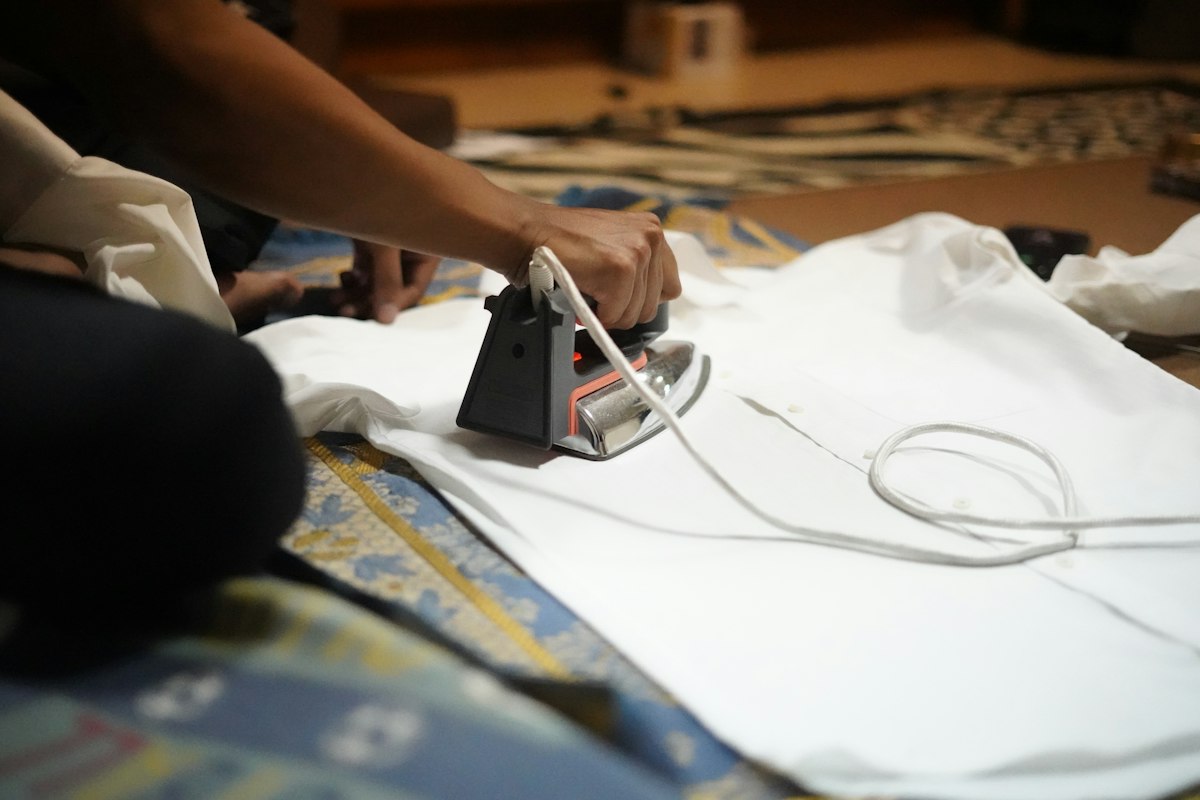 Ironing a white shirt with a black iron